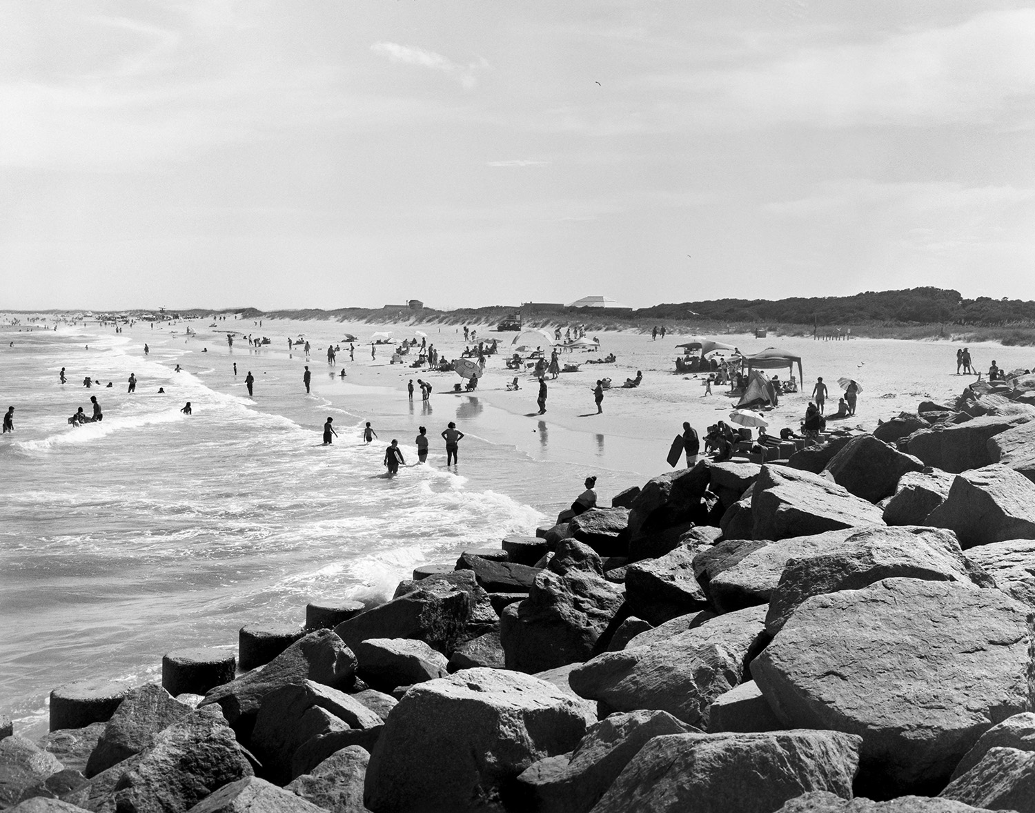 Black and white photo of a rocky beach with people